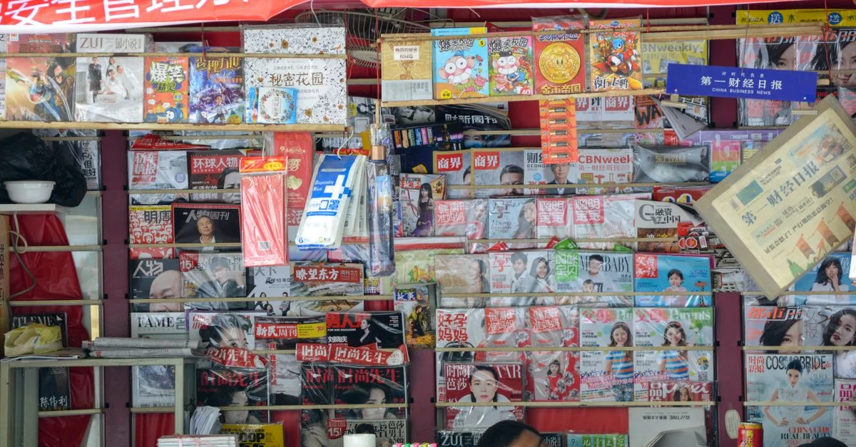 Kiosque vibrant en Chine affichant une variété de magazines et de journaux.
